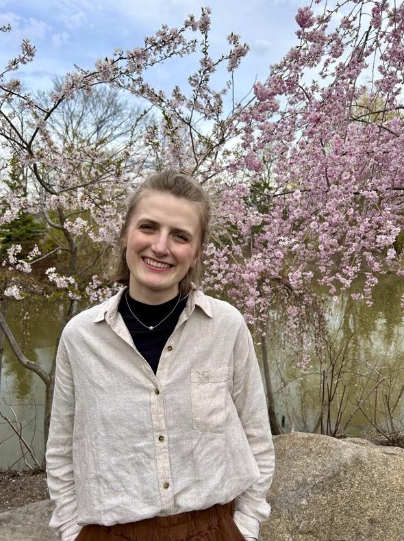Jessica Stehouwer in front of a blooming cherry blossom tree.