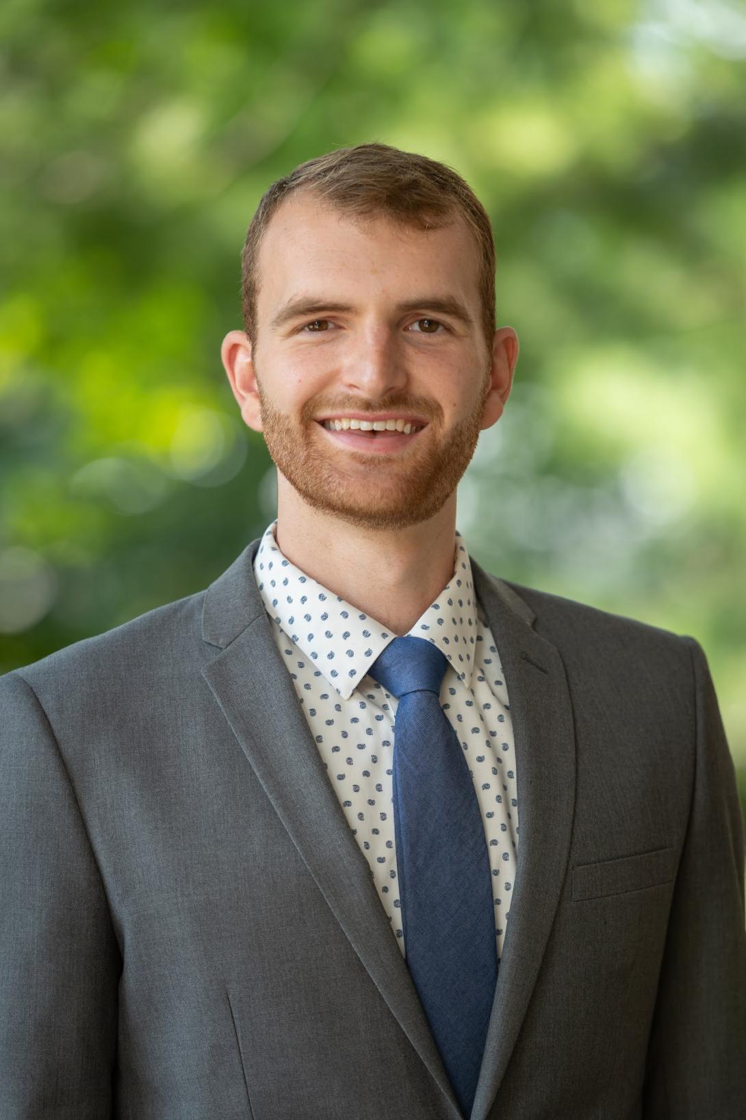 Tanner Vincent in a gray suit with a blue tie