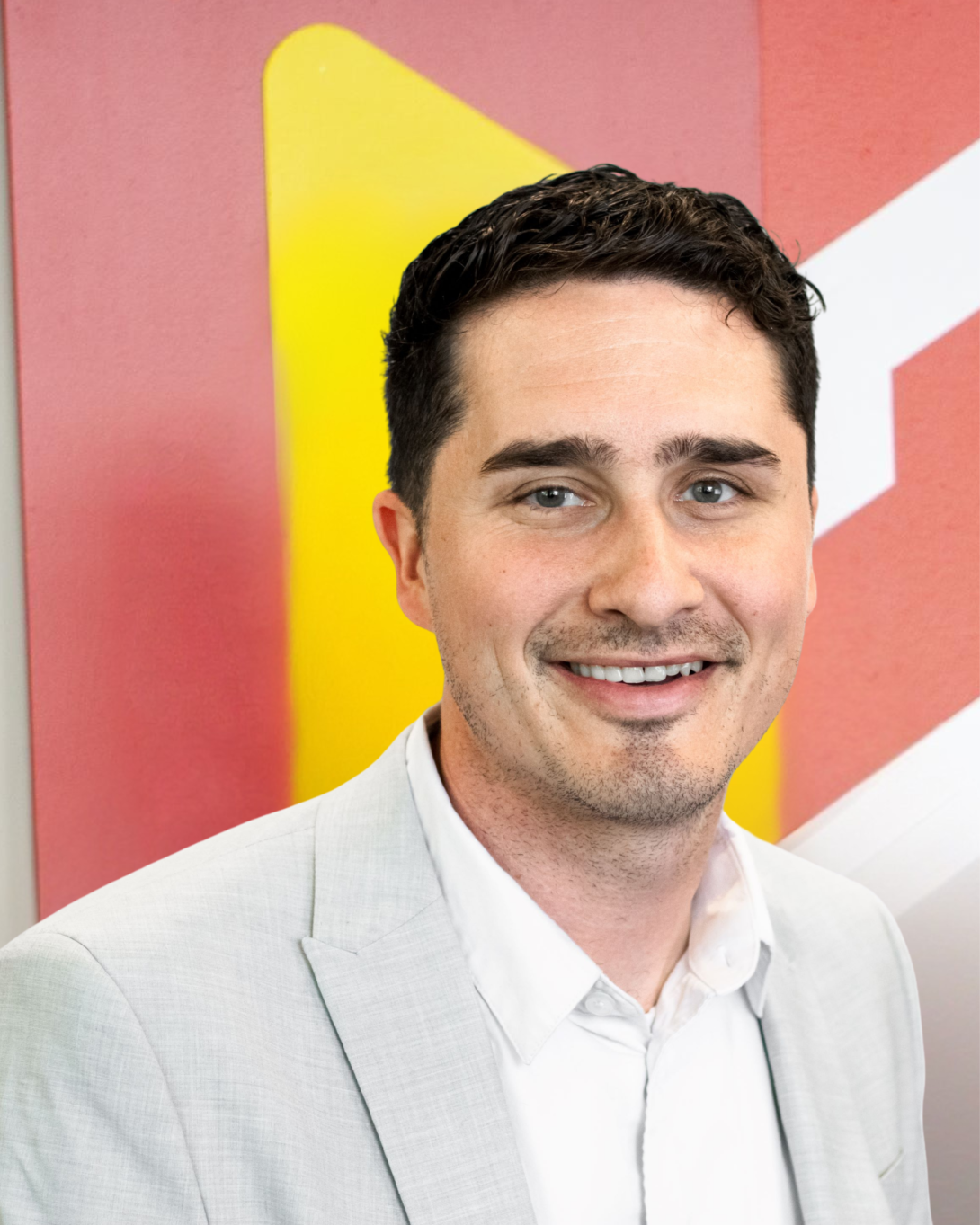 Coty Seaver smiling in front of the Calvin University emblem. 