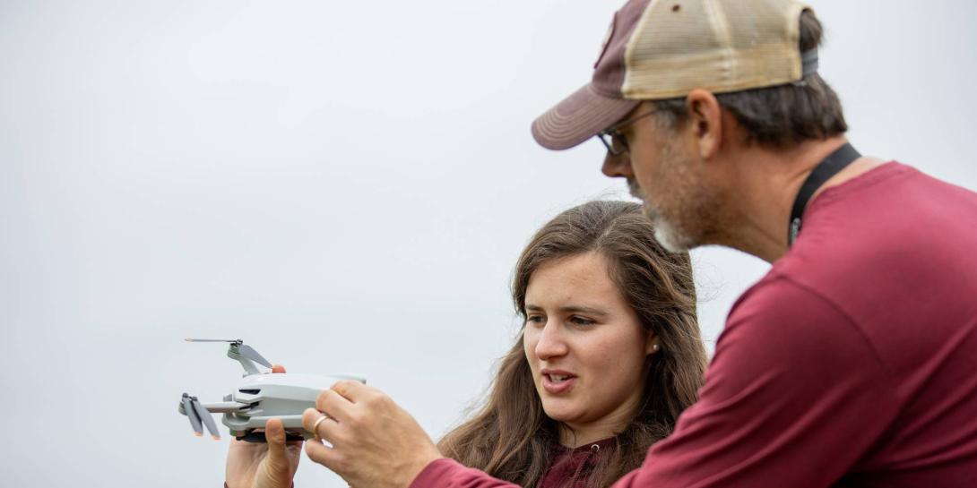 Professor Jason VanHorn working with a student operating a drone.