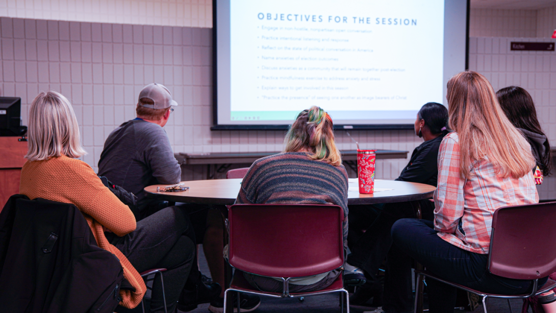 An image of people focused at what the speaker is saying