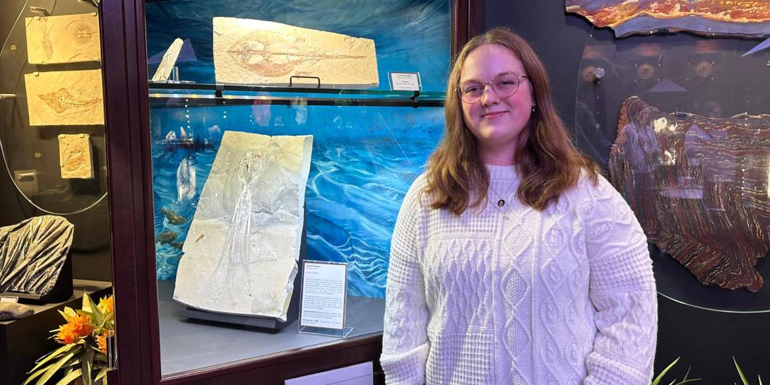 Elizabeth Ayers standing with her artwork in the Dice Museum.