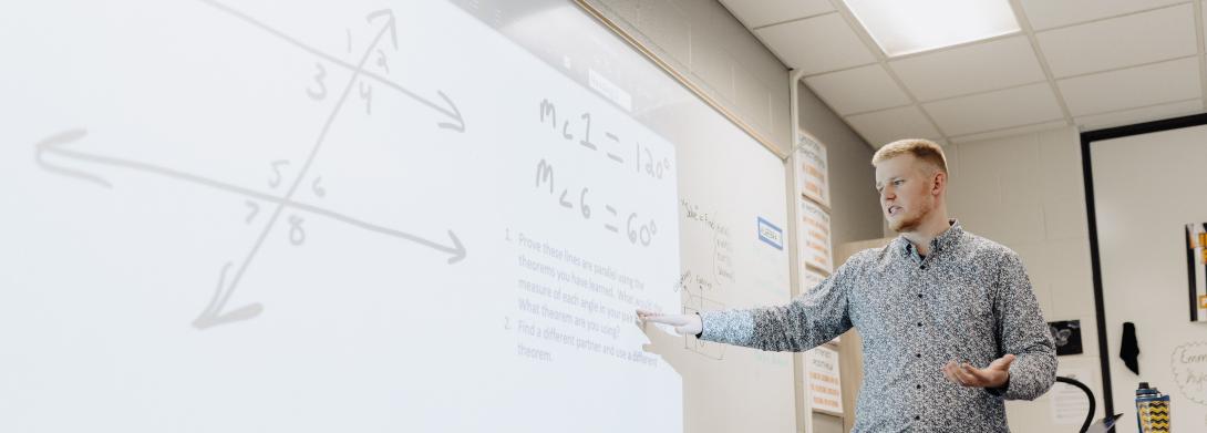 A male student teaching in a classroom