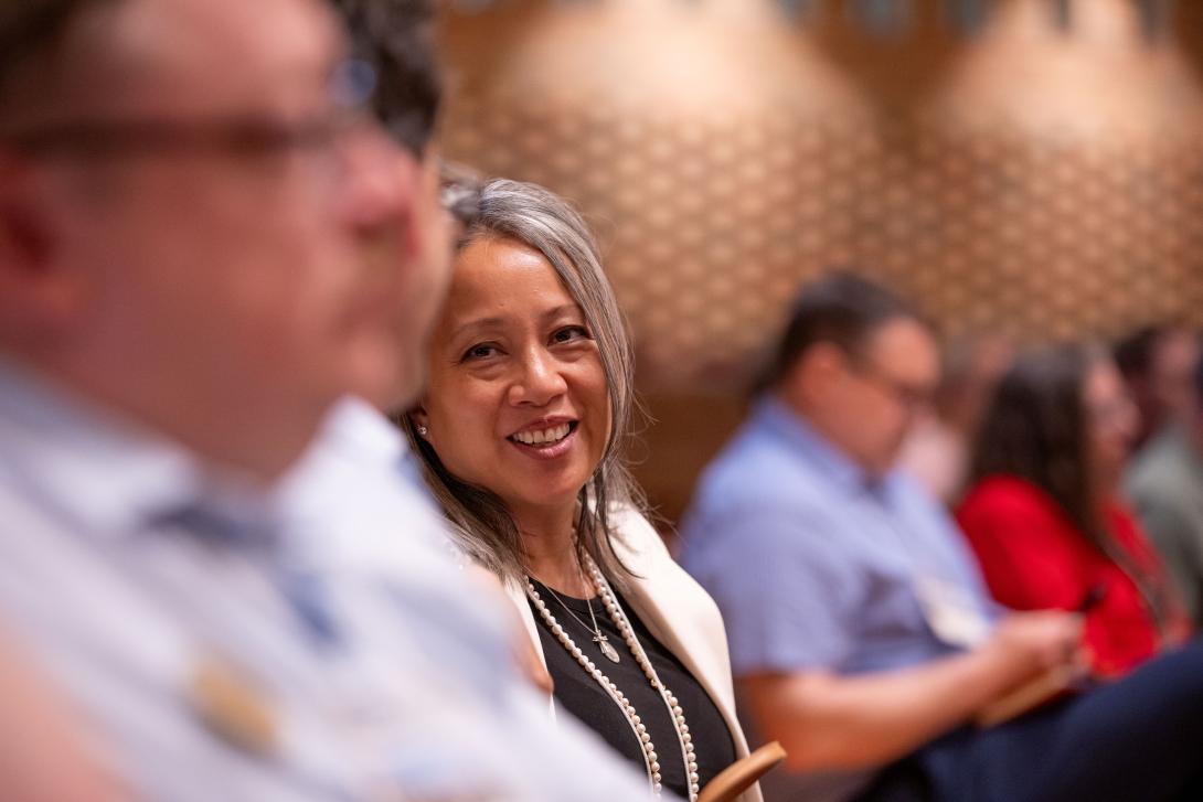Woman looking at the camera in a room of others