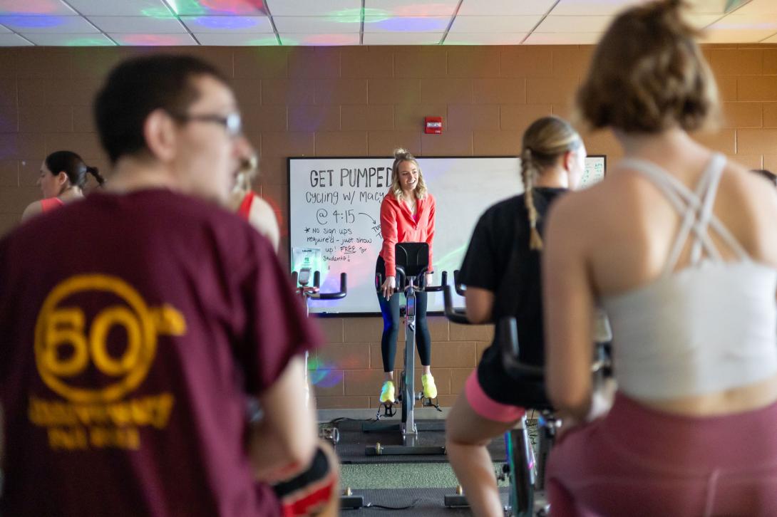 Macy Gerig leads Calvin students in a group fitness spin class.