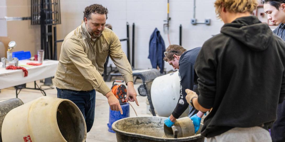Tim Lautenbach helping students in concrete lab.