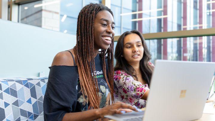 Two students work together on a computer
