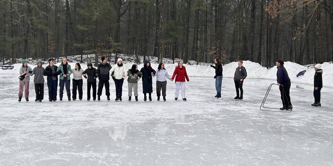 Calvin University students with ice skates on stand in line arm-in-arm