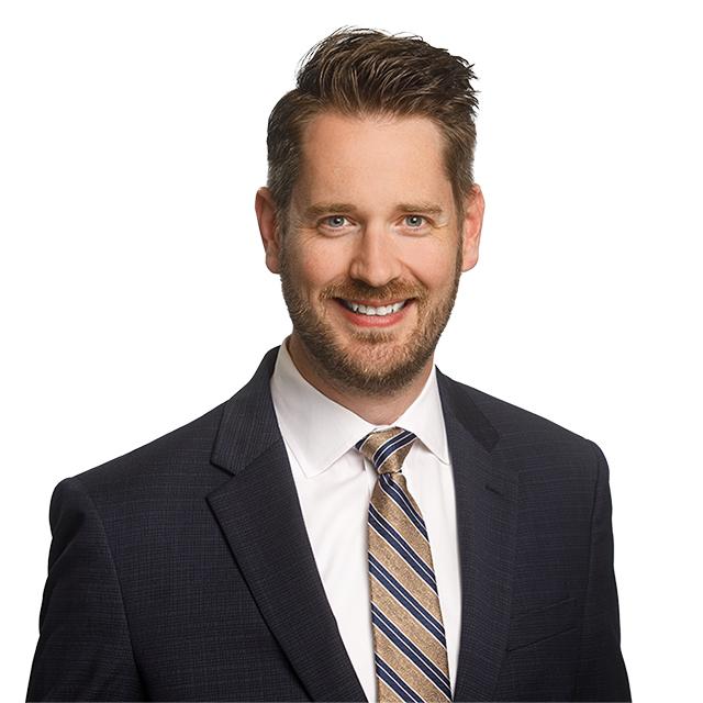 Justin Ooms in a suit and tie