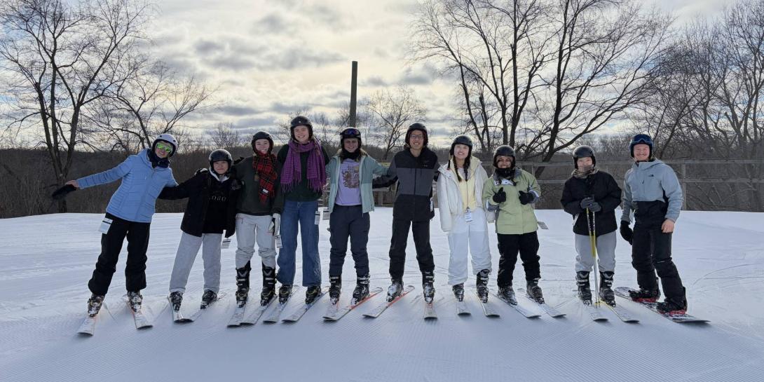 Calvin University students stand in a line with skis on