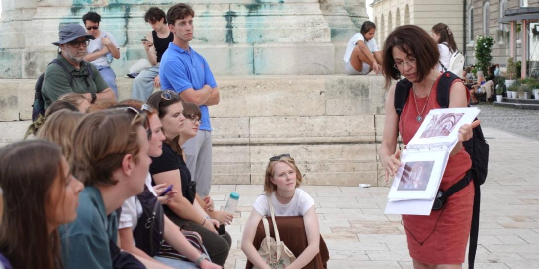 Dora Sallay shows artwork to Calvin students on an outdoor tour in Hungary.