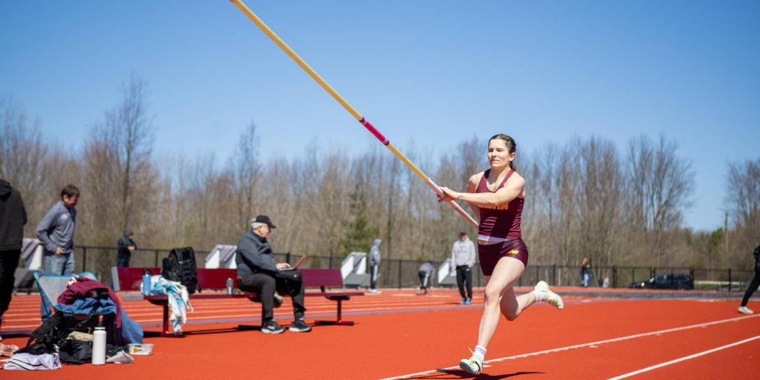 A student from Calvin pole vaulting