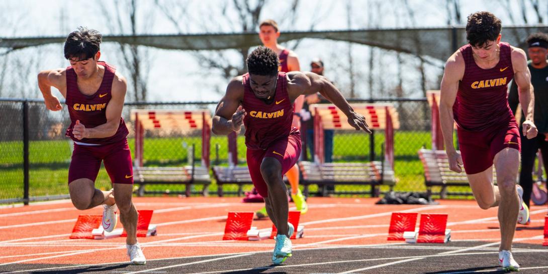 Three Calvin students run on an outdoor track