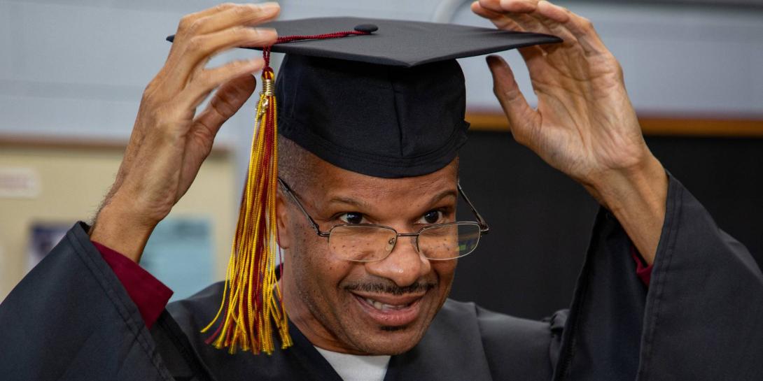 RobertB.Moore adjusts his cap before the 2026 Calvin Prison Initiative graduation.