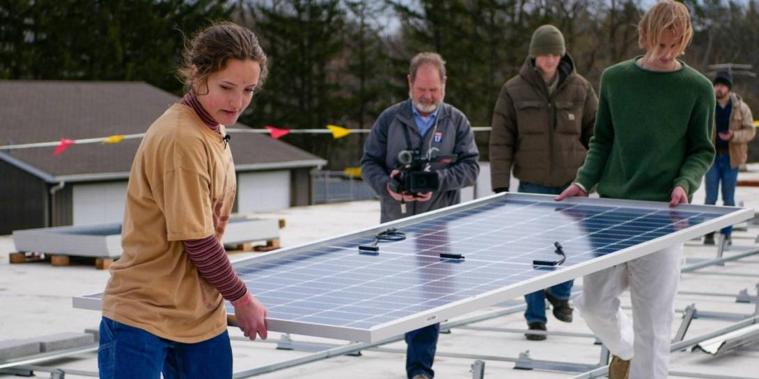 Sofie Schumerth helps install solar panels on roof at Calvin University
