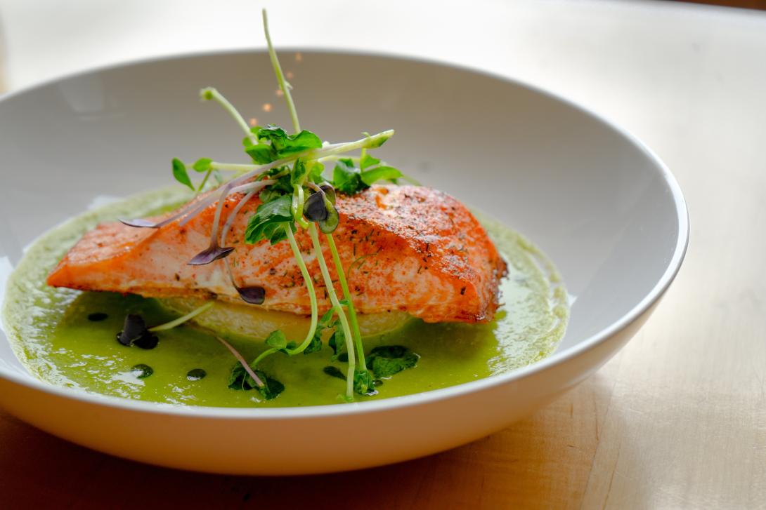 Salmon on a plate of pea puree. 