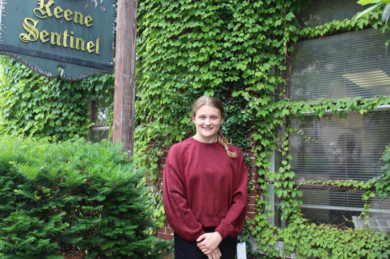 Abbie Hamm in front of an ivy-covered building.