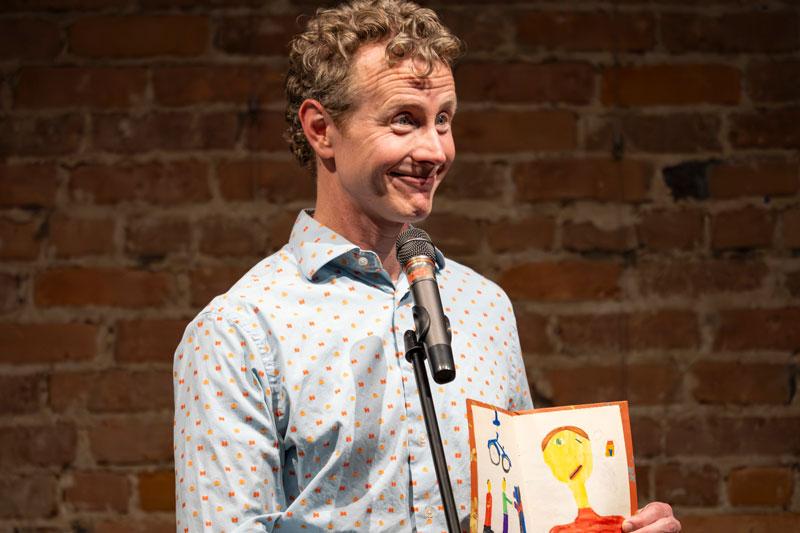 Adam Mellema holds a picture colored by a child.