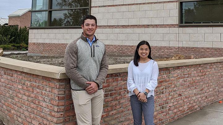 Jeff Erickson and Faith Schultz smile outside the School of Business.