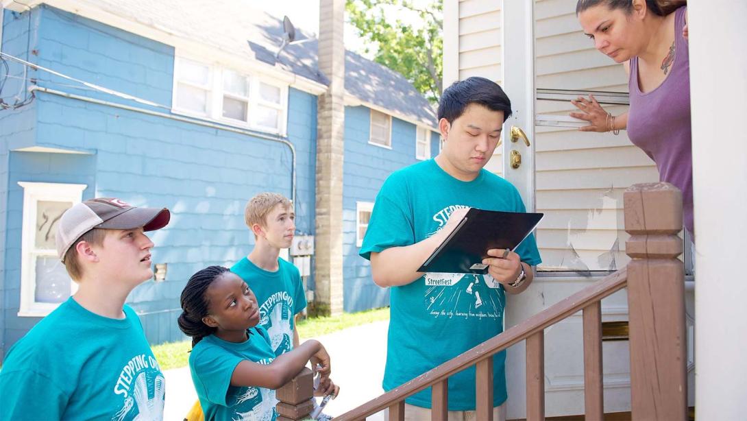 Four Calvin University students survey homeowners in Grand Rapids as part of a service project