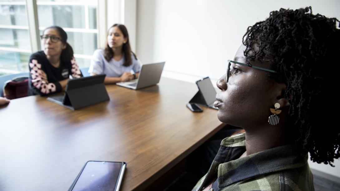 A professor speaking to a full class of graduate students.