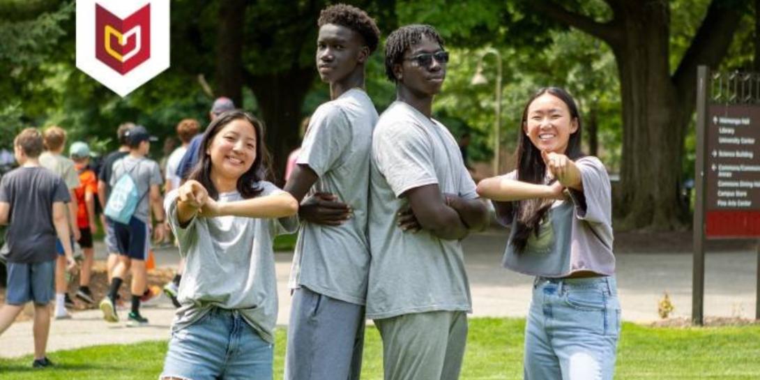 Four students pose on the Commons Lawn at Calvin University.