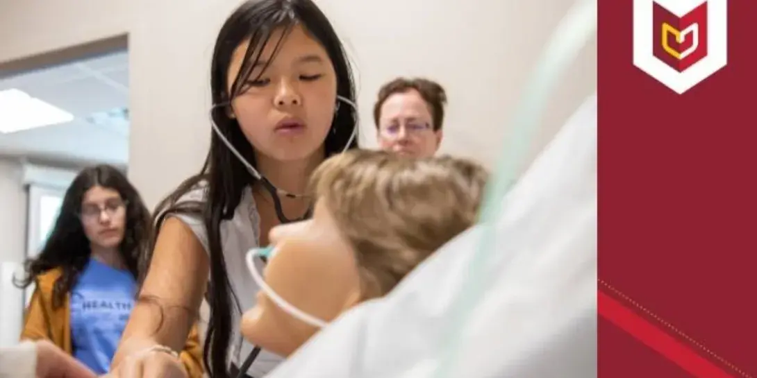 A girl checks the vitals on a manikin during Health Camp 2023 at Calvin University.