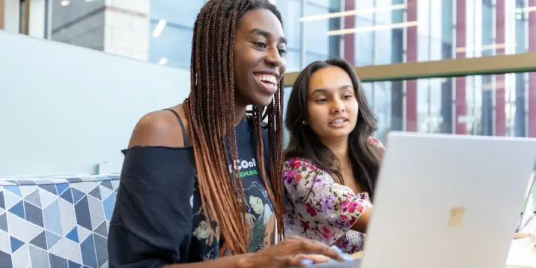 Two students work together on a computer