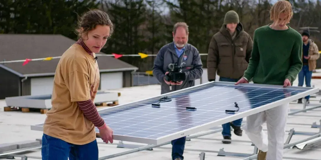 Sofie Schumerth helps install solar panels on roof at Calvin University
