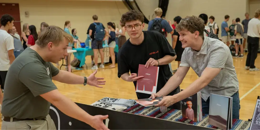 Students gather at a table highlighting Dialogue, a student organization at Calvin