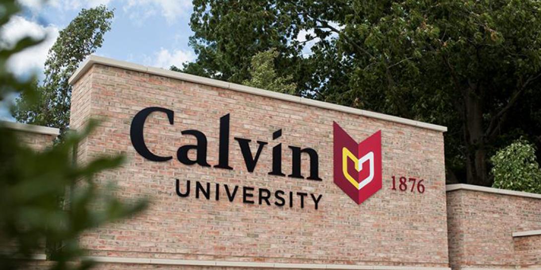 A  monument sign that says Calvin University located at the university's main entrance to campus