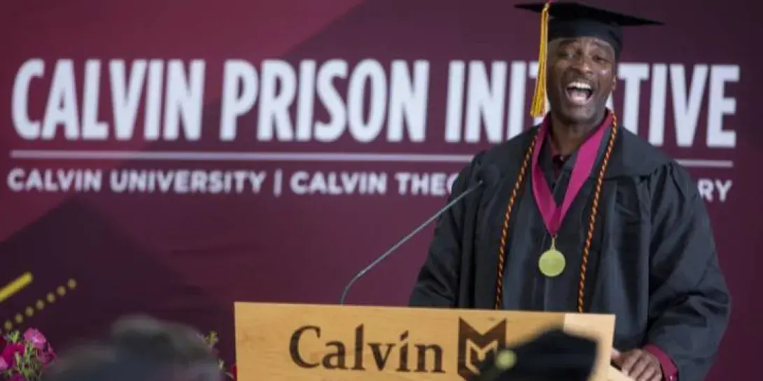 Shawn Davis '24, a graduate of Calvin University, delivers remarks behind a podium.