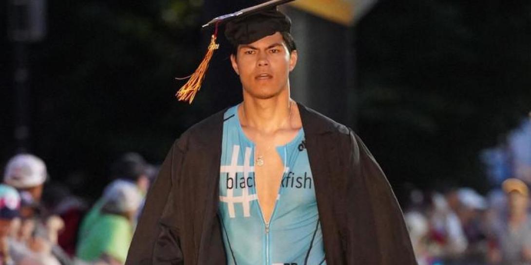 Calvin graduate Mitch Wong walking across the finish line