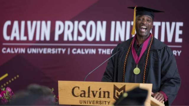 Shawn Davis '24, a graduate of Calvin University, delivers remarks behind a podium.