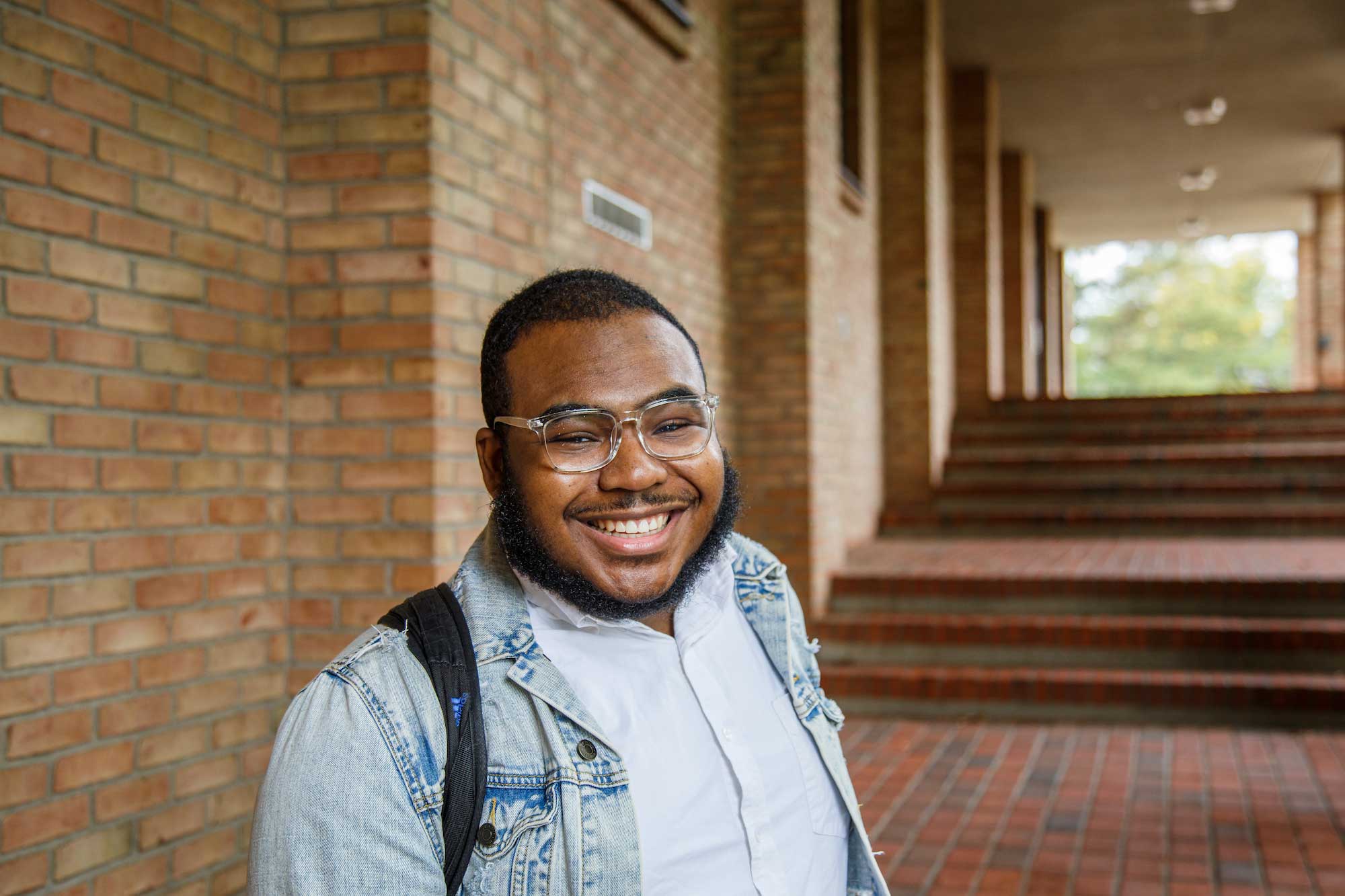 A student with a backpack in front of Hiemenga Hall.
