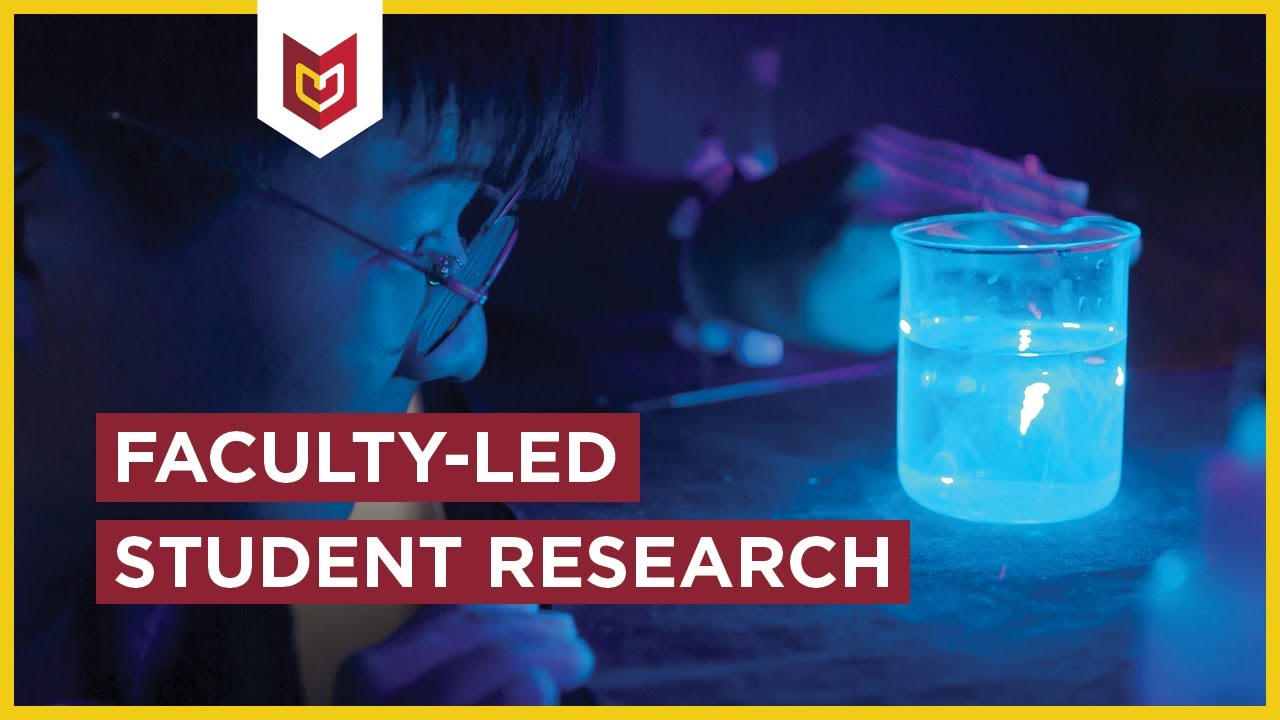 A student examines a beaker, with tile Faculty-led student research.