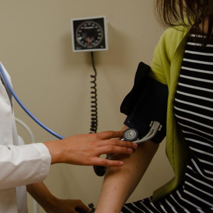 A nurse takes the blood pressure of a patient.