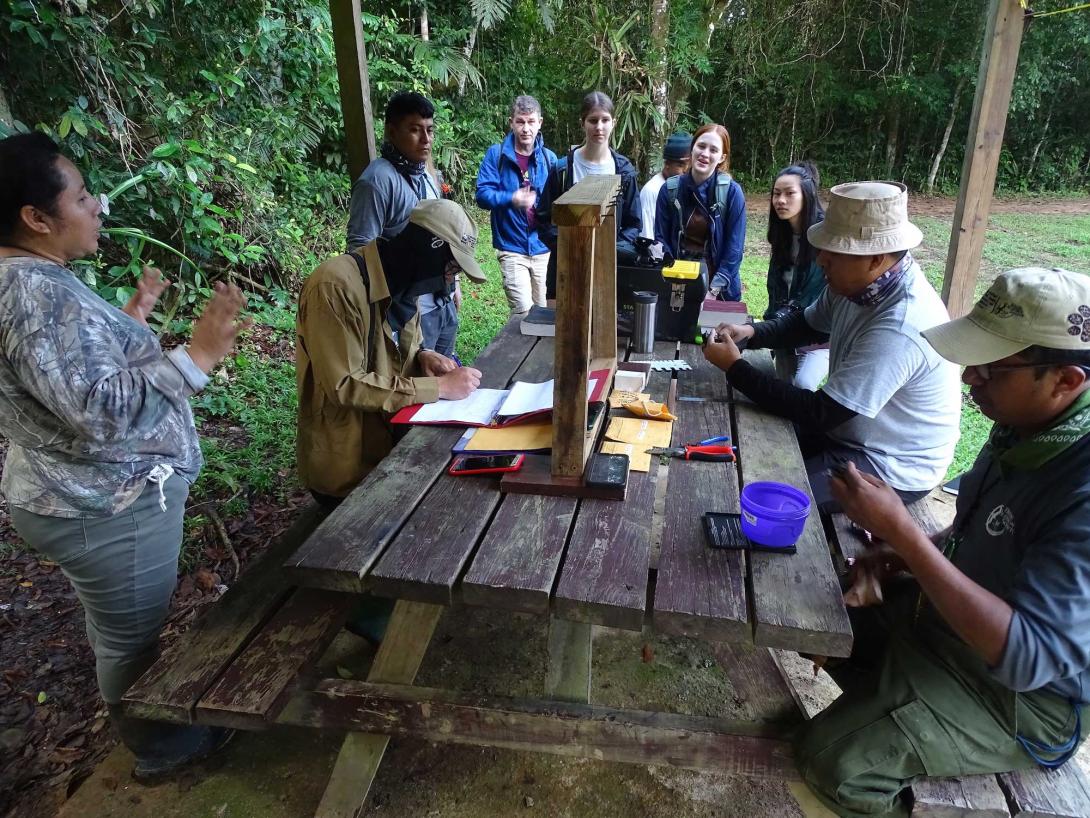 Students and locals around a picnic table in central America.