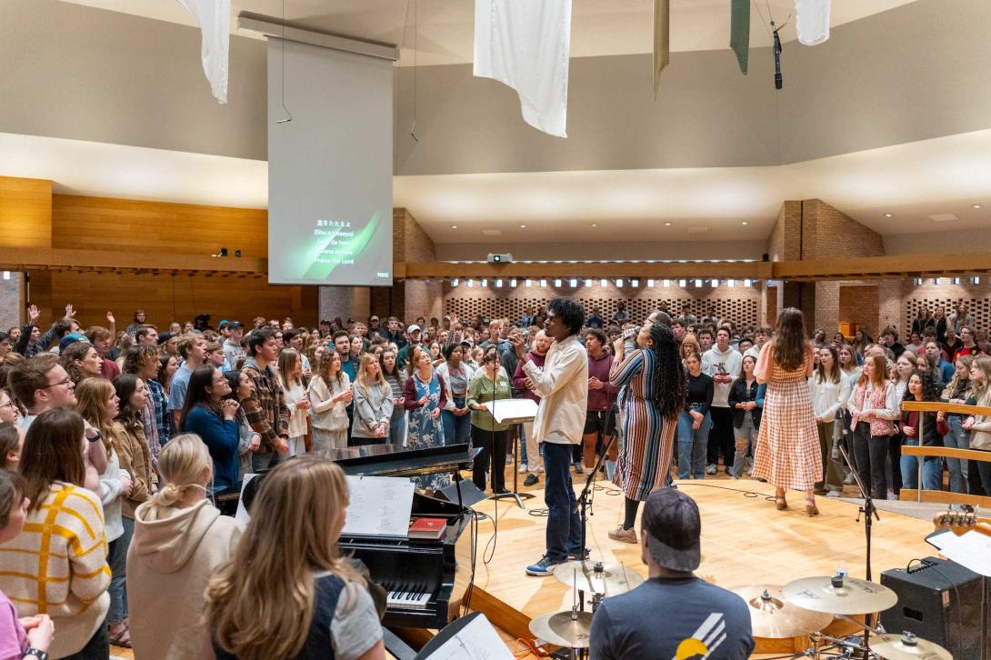 The calvin chapel filled with students while the worship team leads worship.